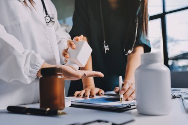 Hastane konferans salonunda kıdemli hekimin sunumu ve sağlık uygulamaları üzerine profesyonel eğitim oturumuna katılan bir grup doktor