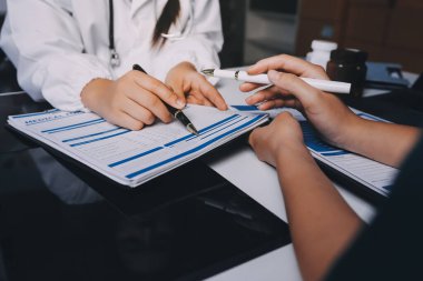 Hastane konferans salonunda kıdemli hekimin sunumu ve sağlık uygulamaları üzerine profesyonel eğitim oturumuna katılan bir grup doktor