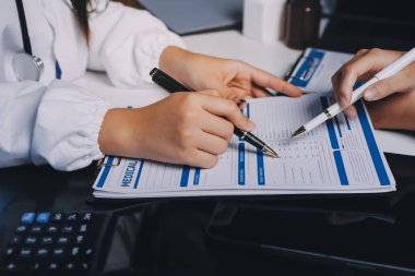 Hastane konferans salonunda kıdemli hekimin sunumu ve sağlık uygulamaları üzerine profesyonel eğitim oturumuna katılan bir grup doktor