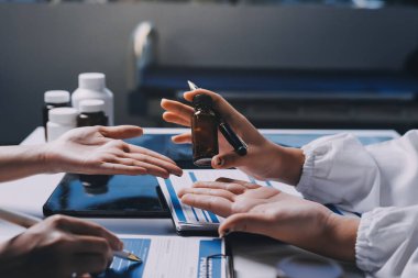 Hastane konferans salonunda kıdemli hekimin sunumu ve sağlık uygulamaları üzerine profesyonel eğitim oturumuna katılan bir grup doktor