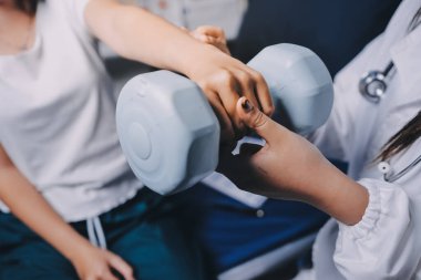 Fizyoterapistle antrenman yapan yaşlı bir kadın. Evde terapist kullanıyor. Huzurevinde yaşlı bir kadına destek oluyor.