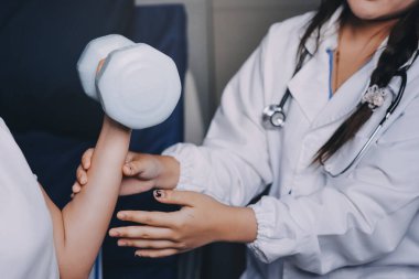 Fizyoterapistle antrenman yapan yaşlı bir kadın. Evde terapist kullanıyor. Huzurevinde yaşlı bir kadına destek oluyor.