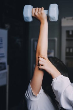 Fizyoterapistle antrenman yapan yaşlı bir kadın. Evde terapist kullanıyor. Huzurevinde yaşlı bir kadına destek oluyor.