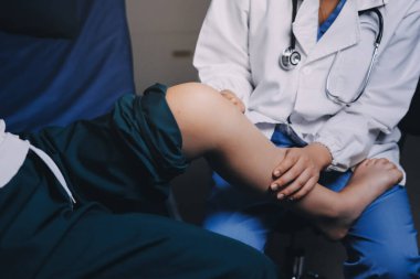 Rehabilitasyon terapisi, rehabilitasyon merkezlerinde çalışan profesyonel erkek fizyoterapistler, erkek hastaların bacak ve kas ağrılarını tedavi ederken,.