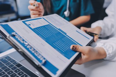 Hastane konferans salonunda kıdemli hekimin sunumu ve sağlık uygulamaları üzerine profesyonel eğitim oturumuna katılan bir grup doktor