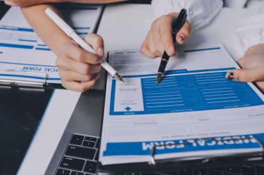 Hastane konferans salonunda kıdemli hekimin sunumu ve sağlık uygulamaları üzerine profesyonel eğitim oturumuna katılan bir grup doktor