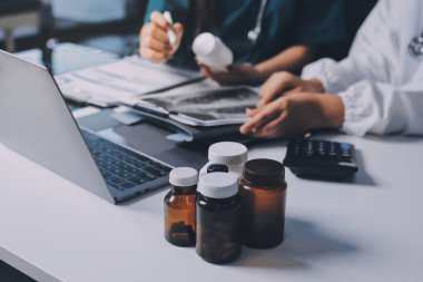 Hastane konferans salonunda kıdemli hekimin sunumu ve sağlık uygulamaları üzerine profesyonel eğitim oturumuna katılan bir grup doktor