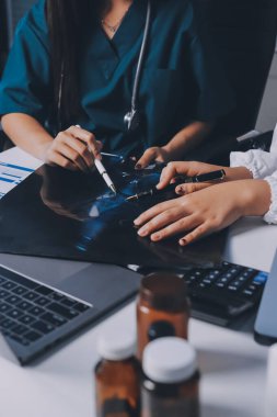 Hastane konferans salonunda kıdemli hekimin sunumu ve sağlık uygulamaları üzerine profesyonel eğitim oturumuna katılan bir grup doktor