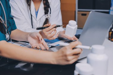 Hastane konferans salonunda kıdemli hekimin sunumu ve sağlık uygulamaları üzerine profesyonel eğitim oturumuna katılan bir grup doktor