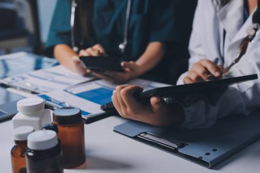 Hastane konferans salonunda kıdemli hekimin sunumu ve sağlık uygulamaları üzerine profesyonel eğitim oturumuna katılan bir grup doktor