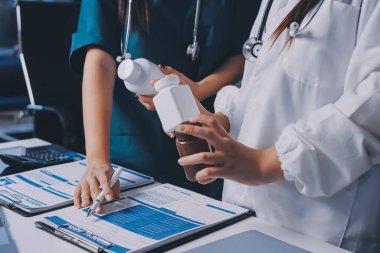 Hastane konferans salonunda kıdemli hekimin sunumu ve sağlık uygulamaları üzerine profesyonel eğitim oturumuna katılan bir grup doktor