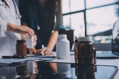 Hastane konferans salonunda kıdemli hekimin sunumu ve sağlık uygulamaları üzerine profesyonel eğitim oturumuna katılan bir grup doktor