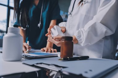 Hastane konferans salonunda kıdemli hekimin sunumu ve sağlık uygulamaları üzerine profesyonel eğitim oturumuna katılan bir grup doktor