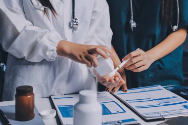 Hastane konferans salonunda kıdemli hekimin sunumu ve sağlık uygulamaları üzerine profesyonel eğitim oturumuna katılan bir grup doktor