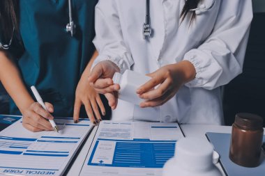 Hastane konferans salonunda kıdemli hekimin sunumu ve sağlık uygulamaları üzerine profesyonel eğitim oturumuna katılan bir grup doktor