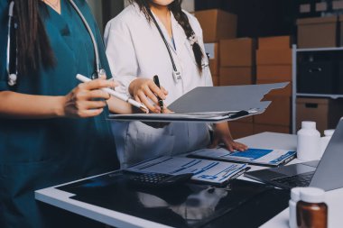 Hastane konferans salonunda kıdemli hekimin sunumu ve sağlık uygulamaları üzerine profesyonel eğitim oturumuna katılan bir grup doktor