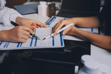 Hastane konferans salonunda kıdemli hekimin sunumu ve sağlık uygulamaları üzerine profesyonel eğitim oturumuna katılan bir grup doktor