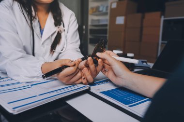 Hastane konferans salonunda kıdemli hekimin sunumu ve sağlık uygulamaları üzerine profesyonel eğitim oturumuna katılan bir grup doktor