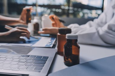 Hastane konferans salonunda kıdemli hekimin sunumu ve sağlık uygulamaları üzerine profesyonel eğitim oturumuna katılan bir grup doktor