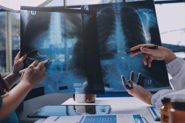 Hastane konferans salonunda kıdemli hekimin sunumu ve sağlık uygulamaları üzerine profesyonel eğitim oturumuna katılan bir grup doktor