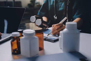 Hastane konferans salonunda kıdemli hekimin sunumu ve sağlık uygulamaları üzerine profesyonel eğitim oturumuna katılan bir grup doktor