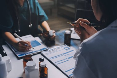 Hastane konferans salonunda kıdemli hekimin sunumu ve sağlık uygulamaları üzerine profesyonel eğitim oturumuna katılan bir grup doktor