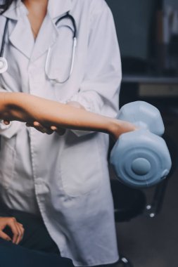 Fizyoterapistle antrenman yapan yaşlı bir kadın. Evde terapist kullanıyor. Huzurevinde yaşlı bir kadına destek oluyor.