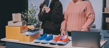 Asyalı bir kadın, sosyal ağda canlı yayında kıyafet satmayı sosyal medyada kıyafet satmayı anlatıyor. Blogger kadın nüfuzlu, KME perakende mağazası sahibi.