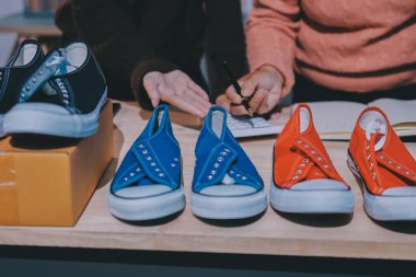 Asyalı bir kadın, sosyal ağda canlı yayında kıyafet satmayı sosyal medyada kıyafet satmayı anlatıyor. Blogger kadın nüfuzlu, KME perakende mağazası sahibi.