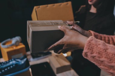 Asyalı bir kadın, sosyal ağda canlı yayında kıyafet satmayı sosyal medyada kıyafet satmayı anlatıyor. Blogger kadın nüfuzlu, KME perakende mağazası sahibi.