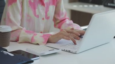 İki finans muhasebecisi dizüstü bilgisayardaki iş tablolarını analiz ediyor, ofis masasında oturuyor, kağıt belgelerine bakıyor, veri tabanlarıyla çalışan hesap makinesi kullanıyor, üstün tabloları kontrol ediyor.