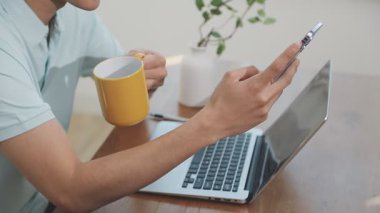 İki finans muhasebecisi dizüstü bilgisayardaki iş tablolarını analiz ediyor, ofis masasında oturuyor, kağıt belgelerine bakıyor, veri tabanlarıyla çalışan hesap makinesi kullanıyor, üstün tabloları kontrol ediyor.