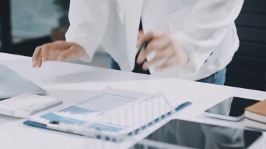 Finans belgesi ve mali muhasebe kavramının rakamlarını hesaplamak için hesap makinesi kullanan bir iş kadını