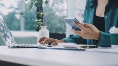 Finans belgesi ve mali muhasebe kavramının rakamlarını hesaplamak için hesap makinesi kullanan bir iş kadını