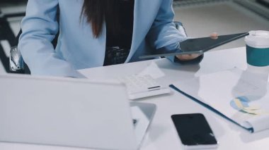 Finans belgesi ve mali muhasebe kavramının rakamlarını hesaplamak için hesap makinesi kullanan bir iş kadını