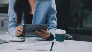 Finans belgesi ve mali muhasebe kavramının rakamlarını hesaplamak için hesap makinesi kullanan bir iş kadını