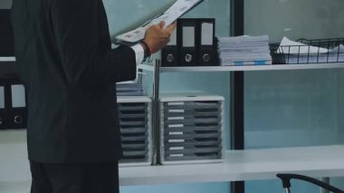 Finans belgesi ve mali muhasebe kavramının rakamlarını hesaplamak için hesap makinesi kullanan bir iş kadını