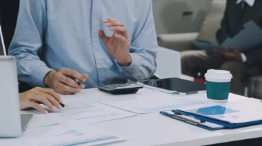 Finans belgesi ve mali muhasebe kavramının rakamlarını hesaplamak için hesap makinesi kullanan bir iş kadını