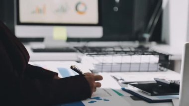 Finans belgesi ve mali muhasebe kavramının rakamlarını hesaplamak için hesap makinesi kullanan bir iş kadını