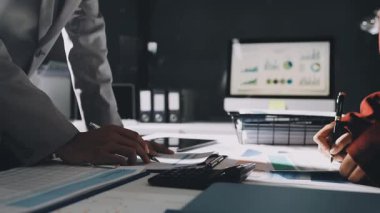 Finans belgesi ve mali muhasebe kavramının rakamlarını hesaplamak için hesap makinesi kullanan bir iş kadını