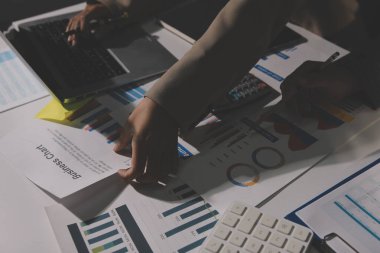 Tablet, akıllı telefon ve dizüstü bilgisayarlı iş belgeleri ve veri tartışan iki iş arkadaşı