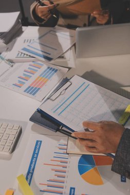 Tablet, akıllı telefon ve dizüstü bilgisayarlı iş belgeleri ve veri tartışan iki iş arkadaşı