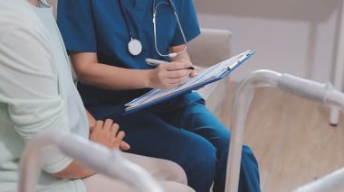 Hemşire kıdemli kadın bacağını muayene ediyor.