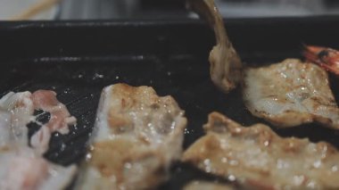 Tayland usulü sıcak tencerede ızgara domuz eti dilimleri.