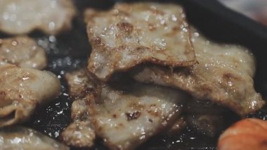 Tayland usulü sıcak tencerede ızgara domuz eti dilimleri.