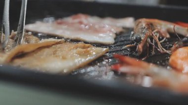 Tayland usulü sıcak tencerede ızgara domuz eti dilimleri.