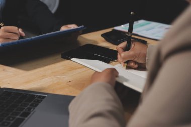 Muhasebe şirketi kazançlı nakit akışı için finansman ve vergilendirme planlaması, ofiste çalışan denetçi ve muhasebeci ekibi, mali verileri ve muhasebe kayıtlarını hesap makinesiyle analiz eder.