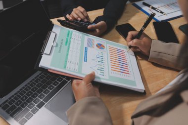 Muhasebe şirketi kazançlı nakit akışı için finansman ve vergilendirme planlaması, ofiste çalışan denetçi ve muhasebeci ekibi, mali verileri ve muhasebe kayıtlarını hesap makinesiyle analiz eder.