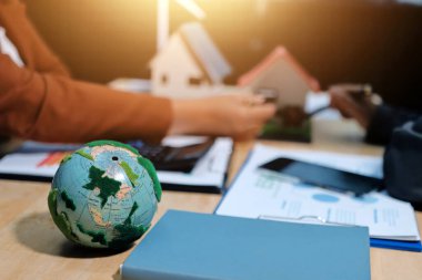 Ekip toplantısında, ESG konu sunumu için dizüstü bilgisayar kullanan Asyalı kadın, çok ırklı iş adamlarından oluşan genç bir gruba liderlik ediyor. Sürdürülebilir iş uygulaması, insanlar ev konseptinde çalışıyor