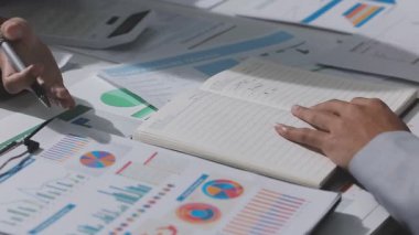 Yatırım sonuçlarını kontrol eden Asyalı erkek finans görevlisi veya muhasebeci, mali bütçe analizi sonuçları özetlemeyi ve denetim konsepti ve yatırım sonuçlarını toplantıya rapor etmeyi planlıyor.